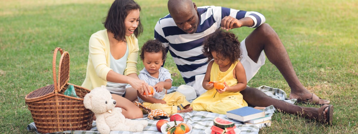 An interracial family enjoys a picnic in the park